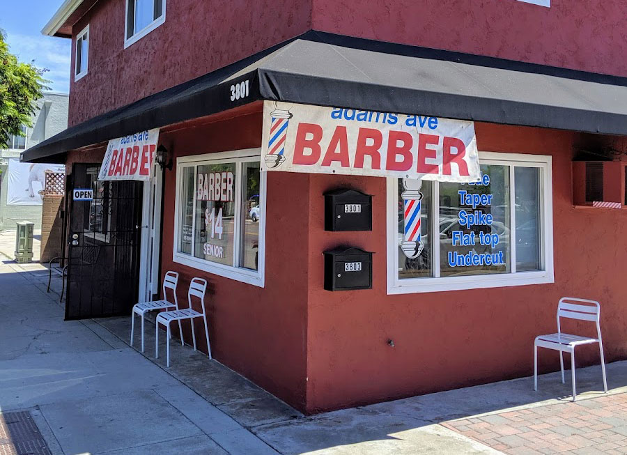Adams Ave Barber Shop at 3801 Adams Avenue, San Diego, with a red exterior, barber signs, and outdoor seating.