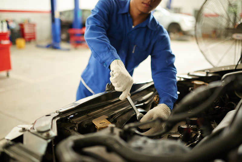 Mechanic performing car engine repair at an auto repair service on Adams Avenue, San Diego.