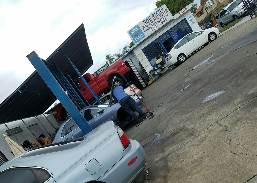 Car Diego Auto Repair shop at 3464 Adams Avenue, San Diego, with mechanics working on vehicles, including a red truck and a silver sedan.