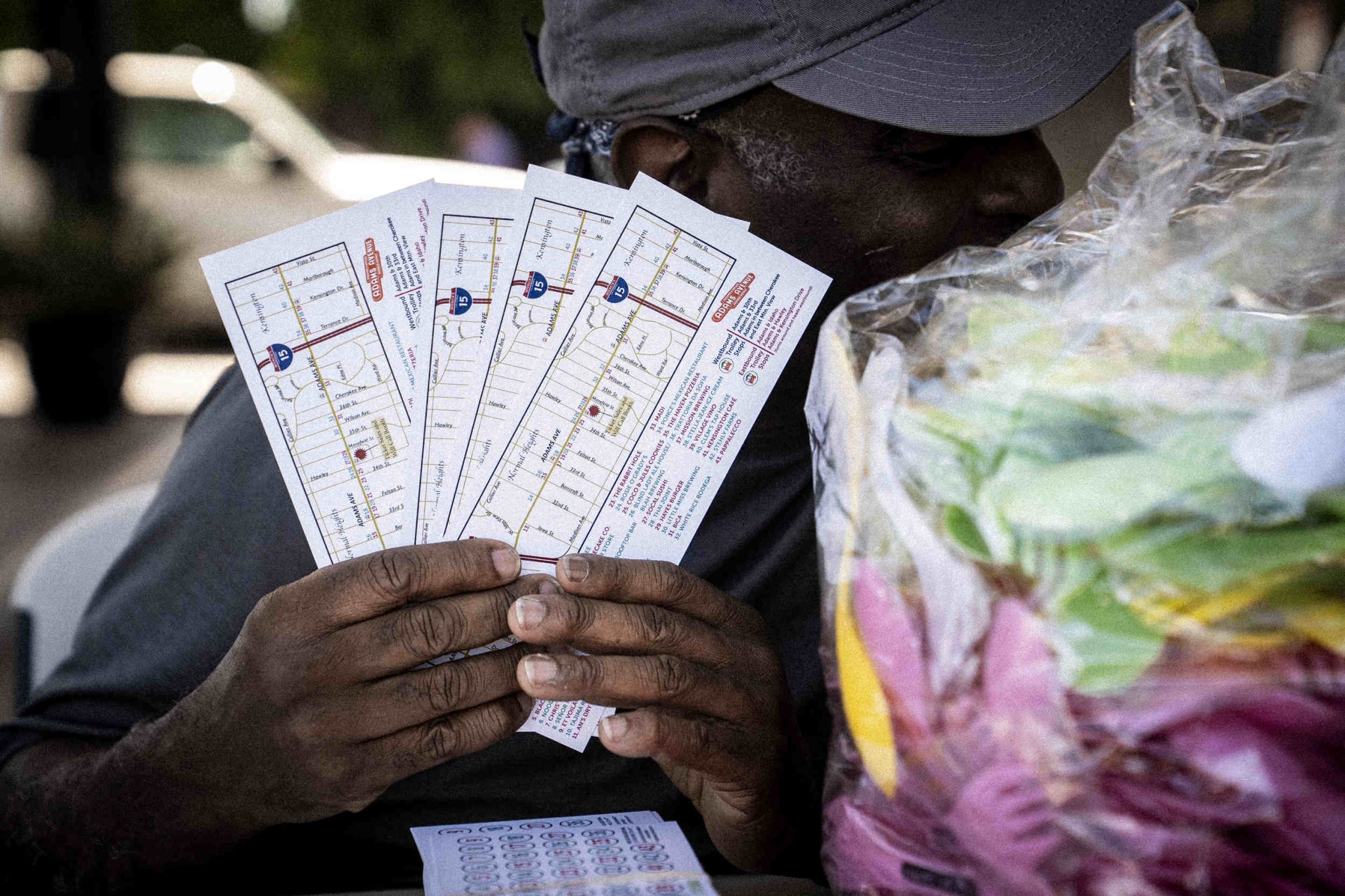 A man holds Taste of Adams Avenue tickets in his hands.