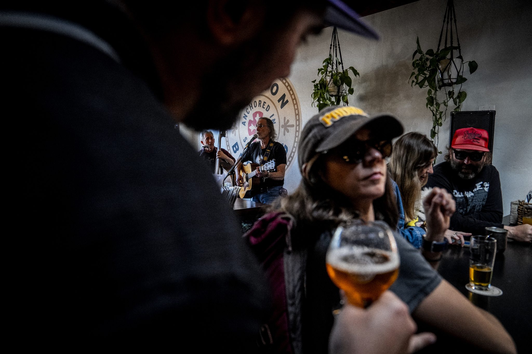 People drink beer while musicians play at Mission Brewery