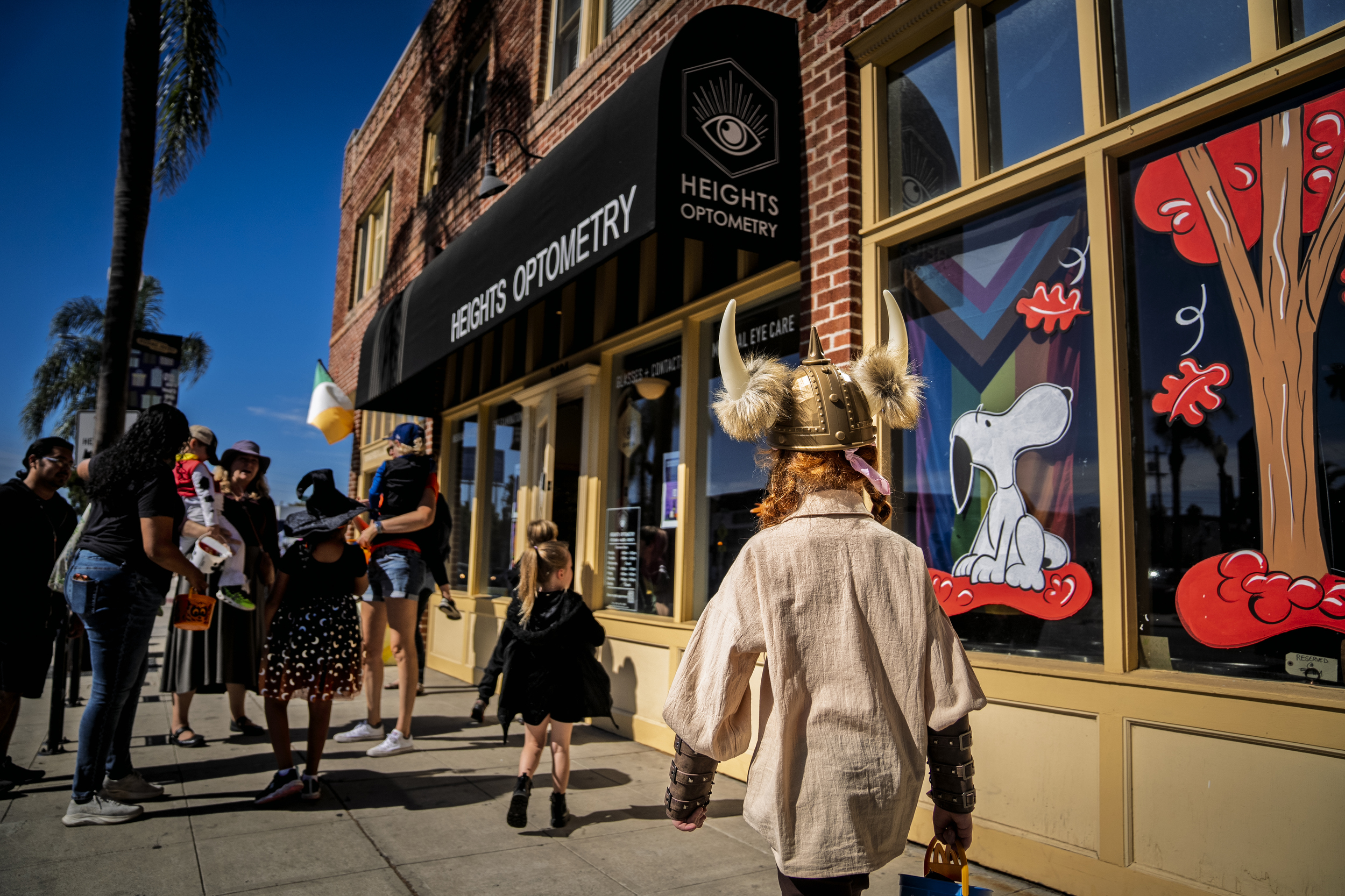 People walk outside Heights Optometry while trick or treating